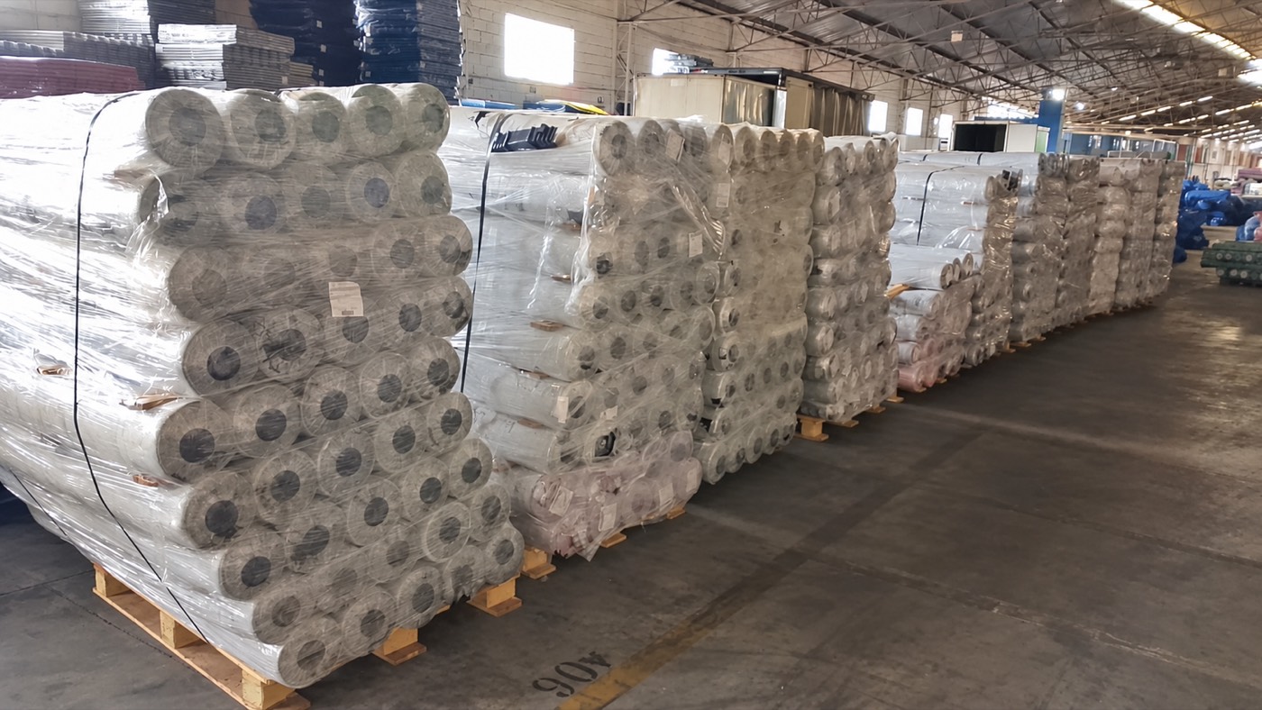 Paletes de rolos embalados no galpão, prontos para expedição